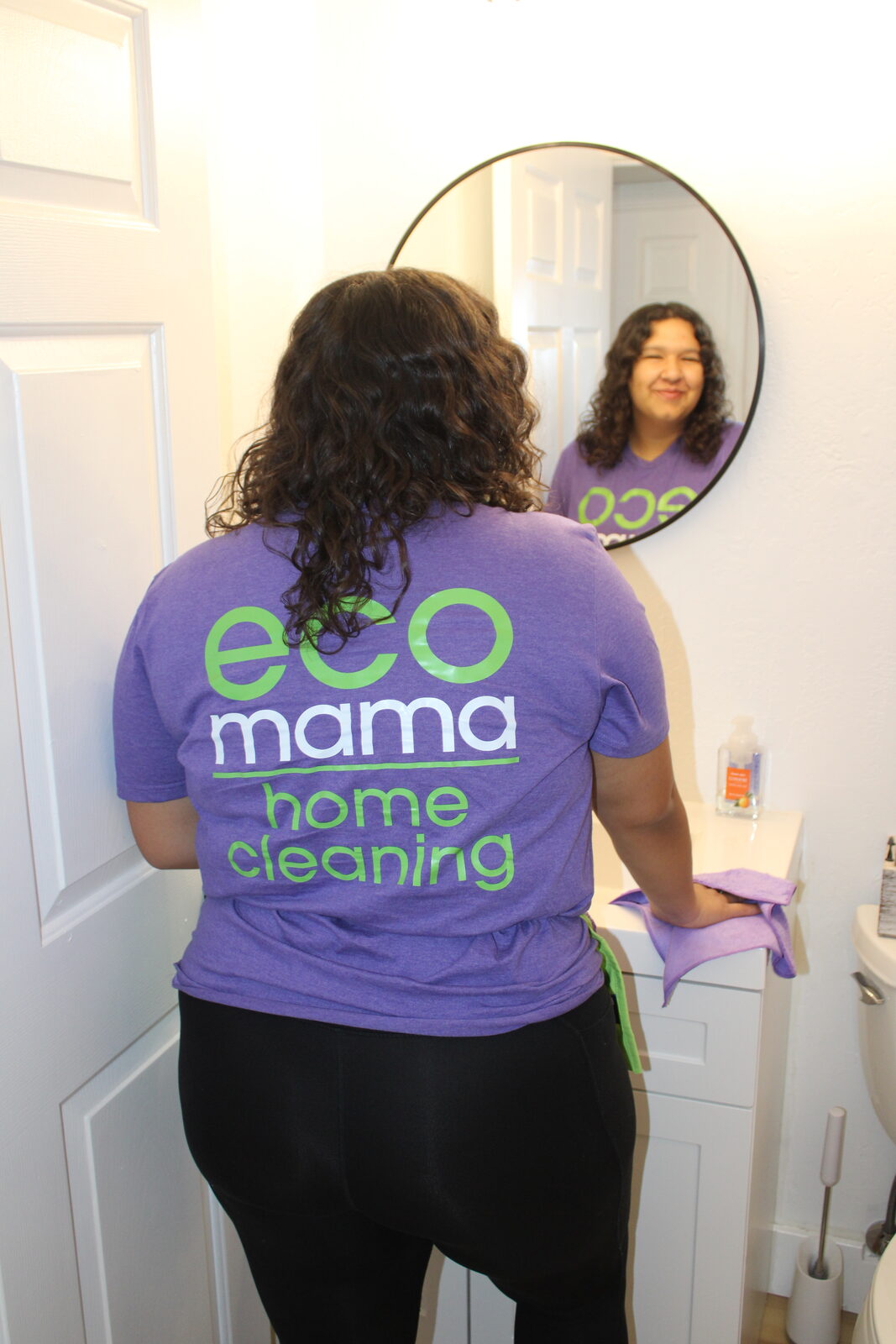 Eco Mama team member cleaning bathroom tile and fixtures in Peoria home