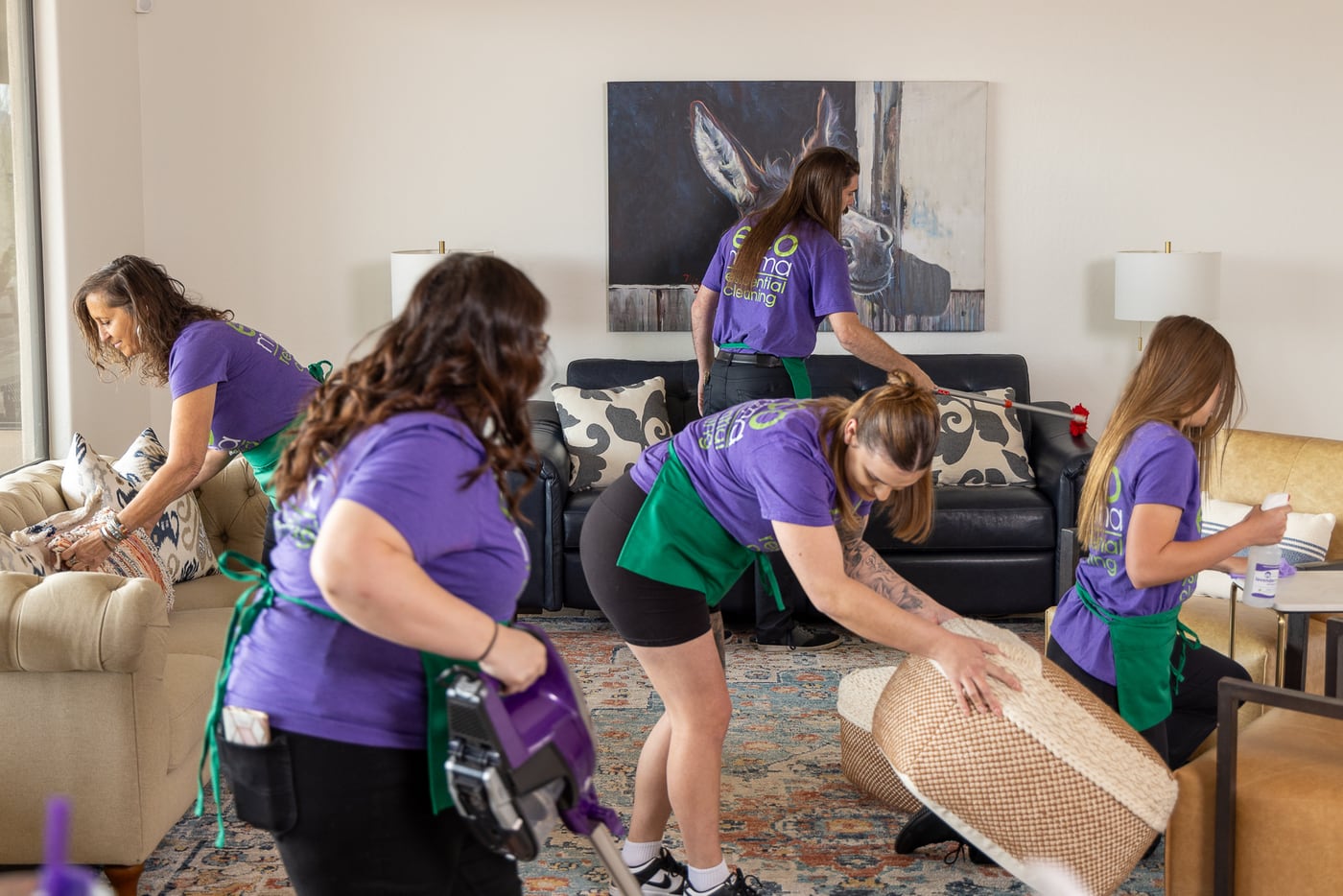 Eco Mama team cleaning a living room, vacuuming and dusting