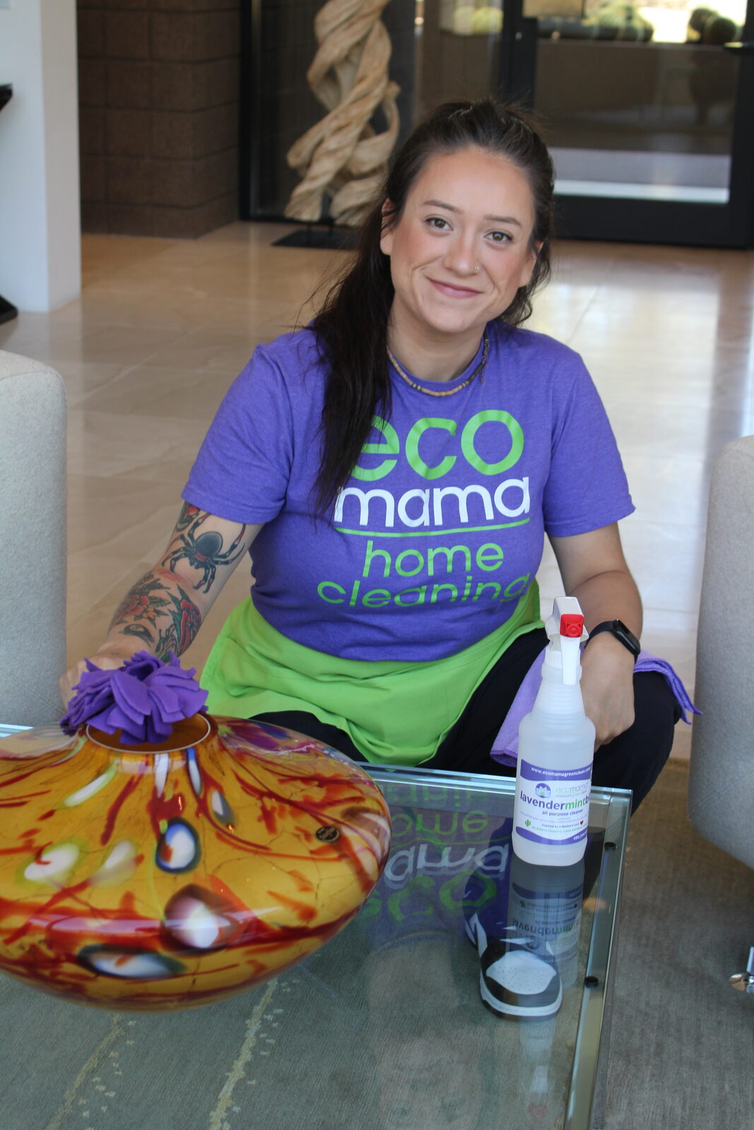 Eco Mama team member cleaning a bright Phoenix living room with eco-friendly products